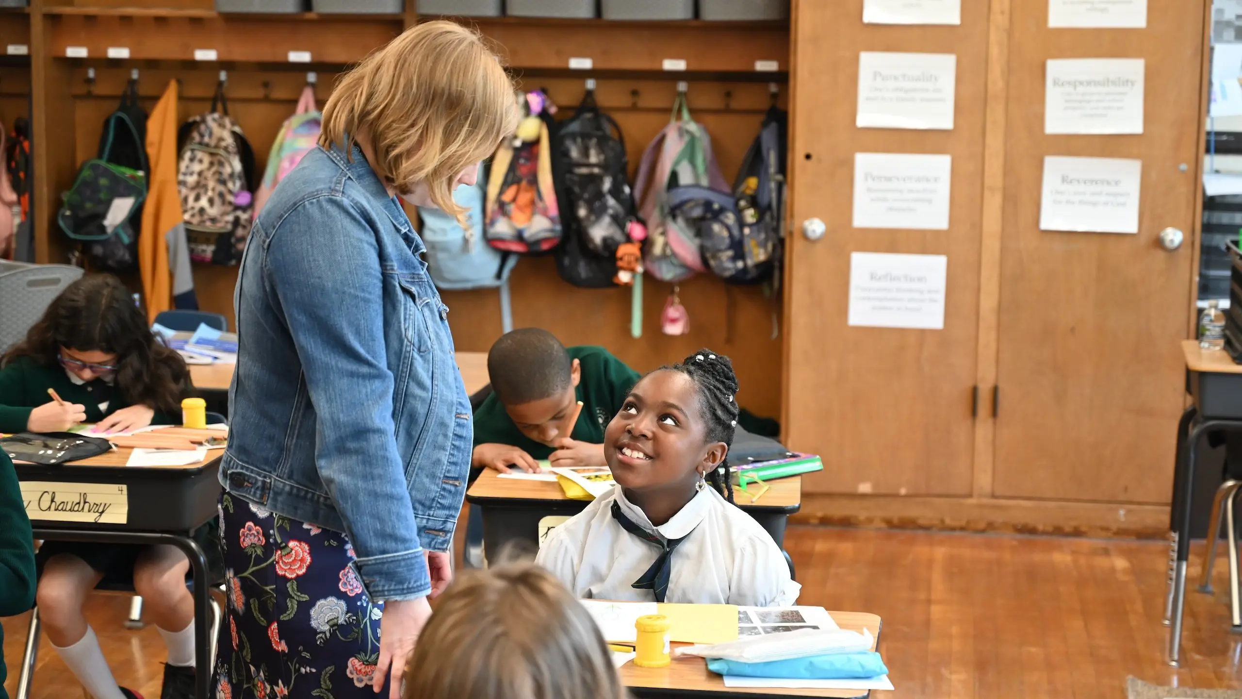 A teacher speaks to a student during a lesson